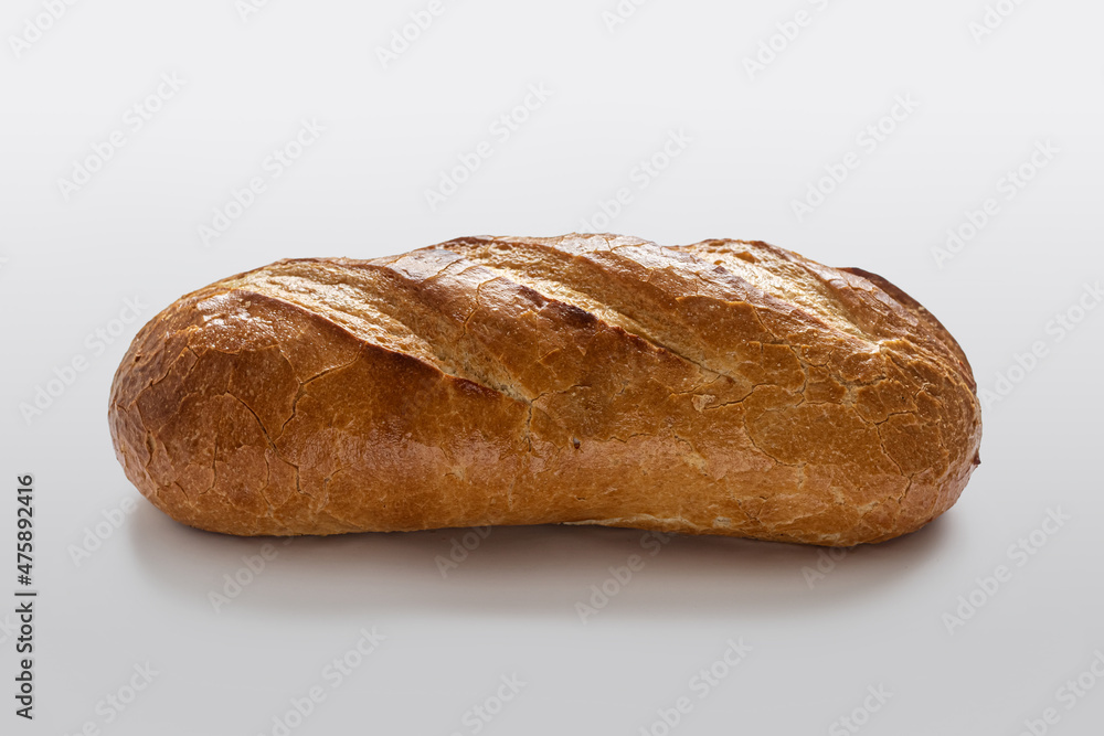 Homemade bread with a golden crust with incisions on top, on a light background Homemade bread with a golden crust with incisions on top, on a light background