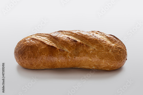 Homemade bread with a golden crust with incisions on top, on a light background