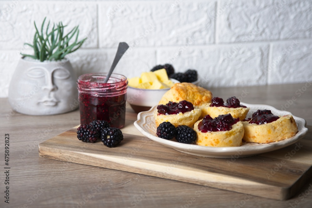 Scones with homemade blackberry jam and fresh blackberries on wooden board Scones with homemade blackberry jam and fresh blackberries on wooden board