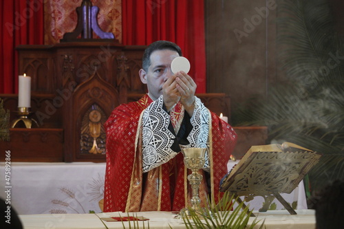 Foto A priest celebrates a catholic mass dressed in a red chasuble