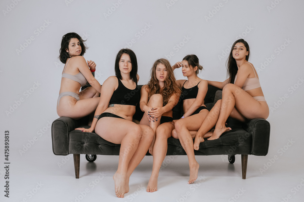 Diverse models wearing comfortable underwear posing on a large sofa