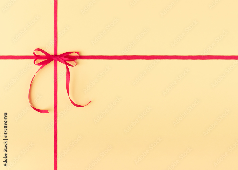 Pink ribbon with bow isolated on yellow pastel background. Flat lay. Copy space. Pink ribbon with bow isolated on yellow pastel background. Flat lay. Copy space.