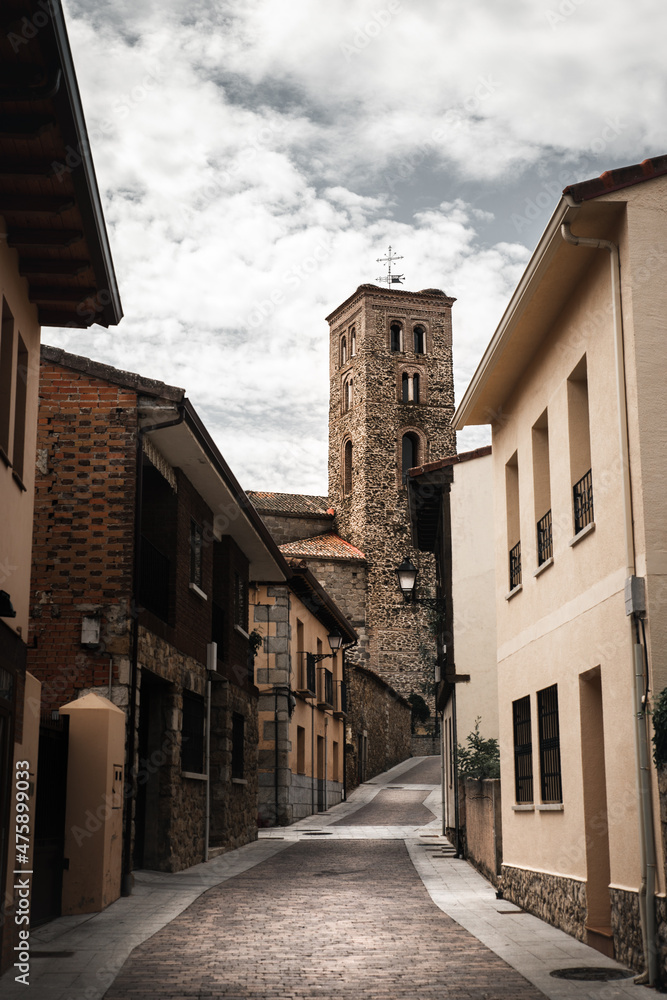 Cobbled street with church in the background (Sierra de Madrid, Buitrago del Lozoya, Spain)