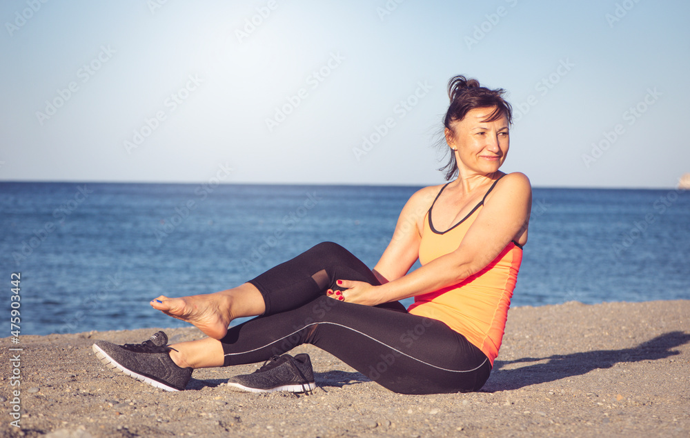 Pleasure of a beautiful woman after sports on the seashore