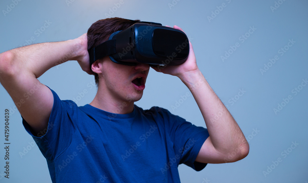 An excited young guy in virtual reality glasses is immersed in the metaverse An excited young guy in virtual reality glasses is immersed in the metaverse