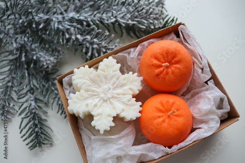 christmas background. handmade christmas candle made of natural soy wax in the shape of snowflake and tangerine