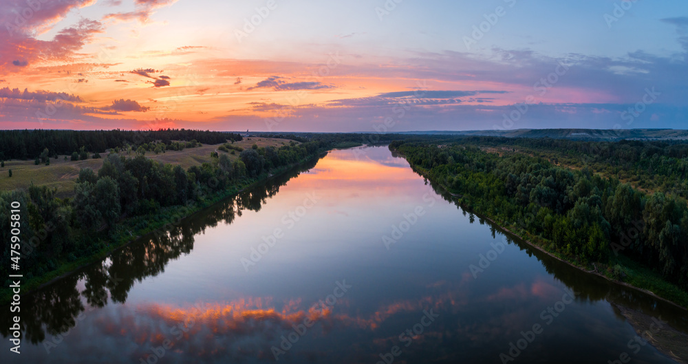 Aerial panoramic landscape with sunset over the river and beautiful clouds on the sky.