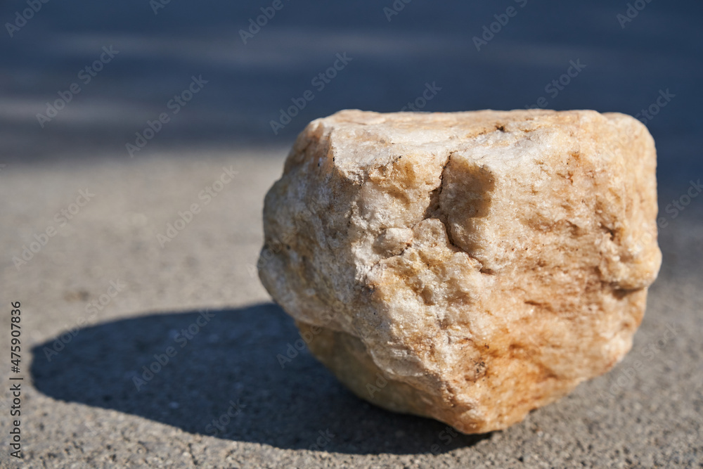 Podium for product presentation. Product display with beige stone texture, a pedestal of natural beauty in sunlight, selective focus. High quality photo Podium for product presentation. Product display with beige stone texture, a pedestal of natural beauty in sunlight, selective focus. High quality photo