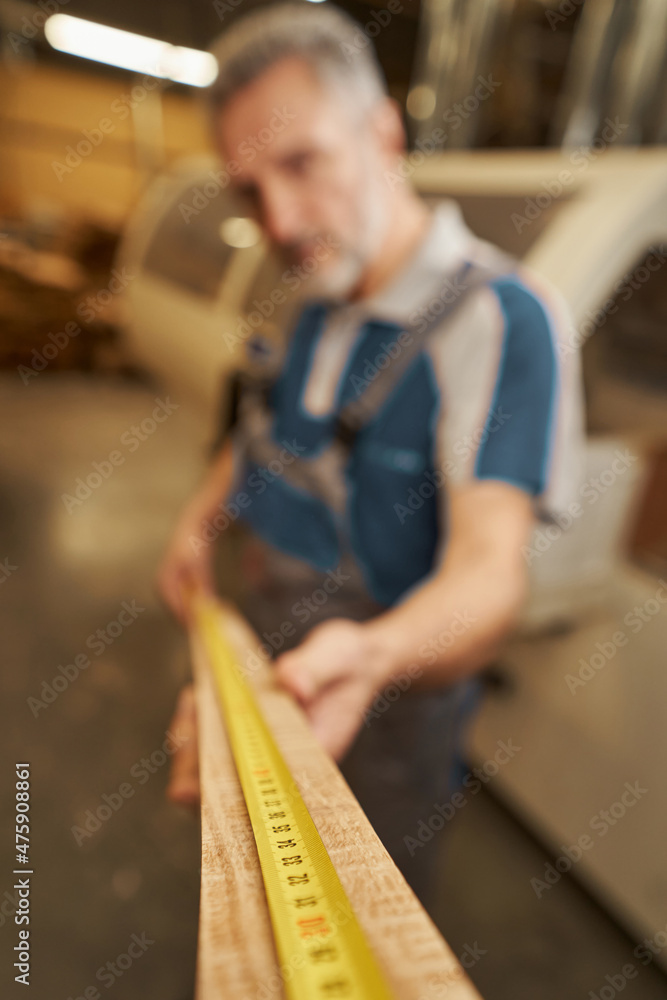 Silhouette of joiner using measuring tape for checking bar Silhouette of joiner using measuring tape for checking bar