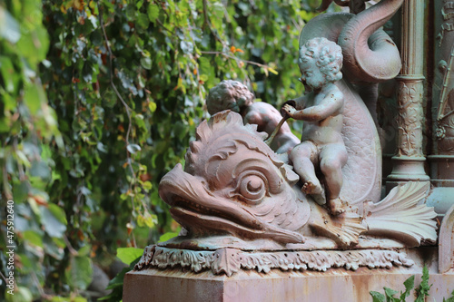 Fotografia Closeup shot of a cherub on the fish statue in the park