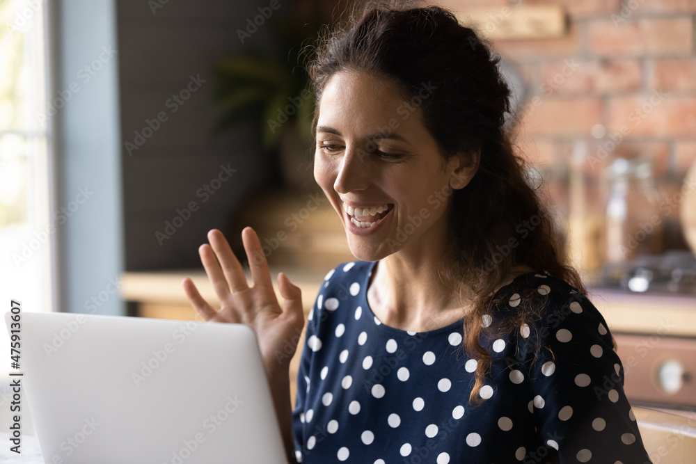 Smiling attractive millennial hispanic woman waving hand looking at camera, starting distant video call meeting with family. Joyful pretty young female blogger recording blog on web camera at home. Smiling attractive millennial hispanic woman waving hand looking at camera, starting distant video call meeting with family. Joyful pretty young female blogger recording blog on web camera at home.
