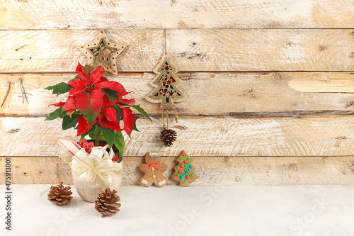 Empty rustic table with poinsettia, cookies and homemade wooden decorations, banner for design, background. Christmas and new year mockup for design and product showcase,  photo