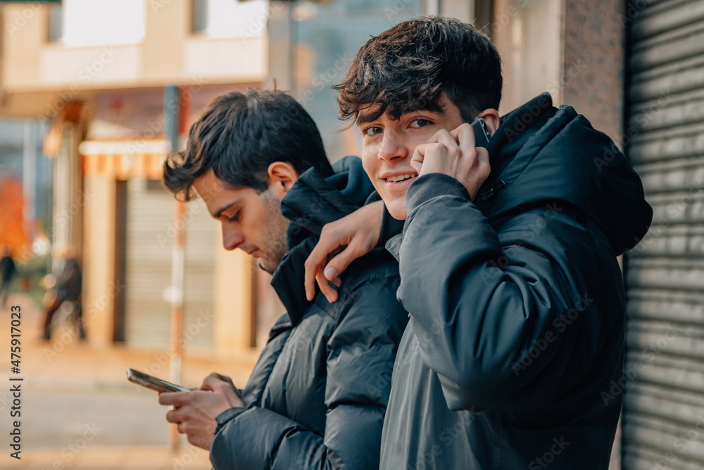 young people with mobile phones or cell phones on the street