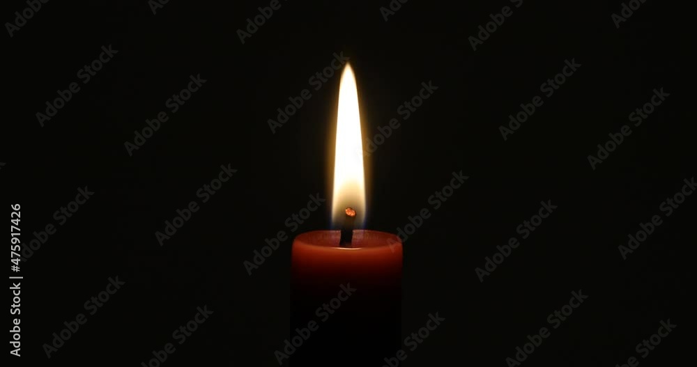 Brennende Kerze vor dunklem Hintergrund, die sich sehr ruhig verhält