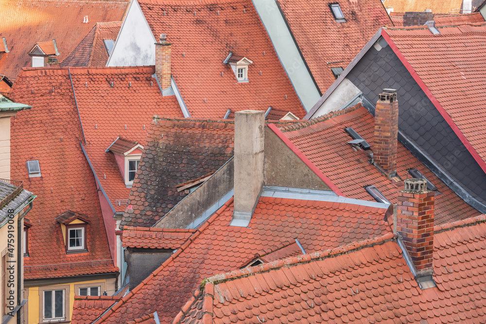 Red tiles roofs and chimneys from different antique buildings in Europe