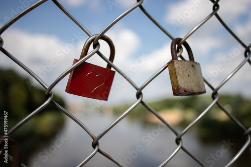 detail of rusty locks with a heart symbol on a fence symbolizing endless love and romance
