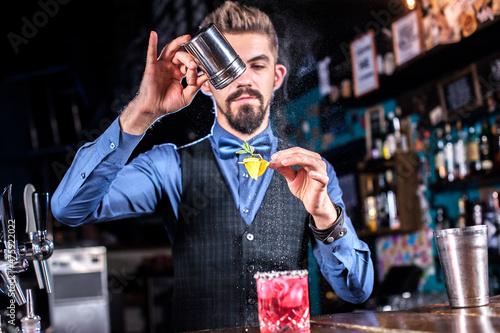 Barman creates a cocktail at the public house photo