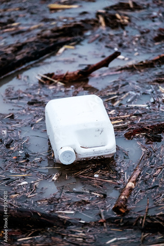 A white jerry can floating on the water in a flooding.  photo