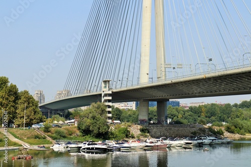 Cable-stayed bridge over the Sava river in Belgrade, anchorage of boats under the bridge 
