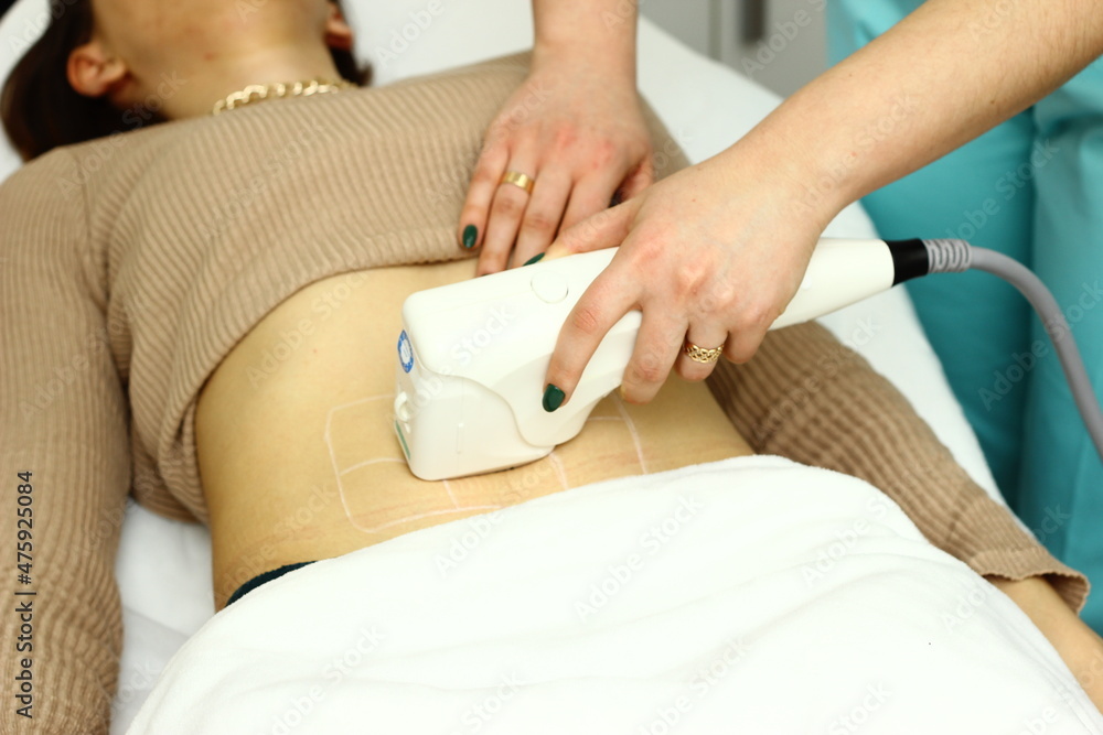 Fototapeta premium Hardware cosmetology. Body care. Spa treatment. Ultrasonic cavitation body contouring treatment. A woman receives anti-cellulite and anti-fat therapy in a beauty salon.