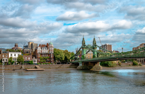 Photography Riverside houses in Hammersmith, West London, England, with the historic Hammersmith Bridge that crosses the River Thames on the right