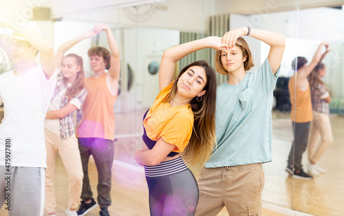 Energetic teens formed pairs and dancing salsa in studio.
