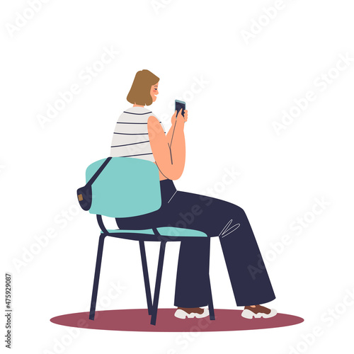 Girl sit on chair with smartphone in hands. Female student making notes to mobile phone