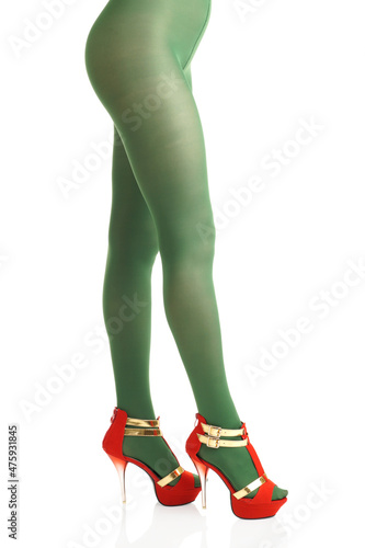 Side view of female legs in green nylon tights and high-heels on isolated white background