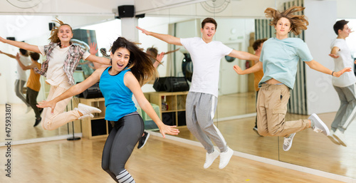 Group of happy teens jumping during exercising in choreography class