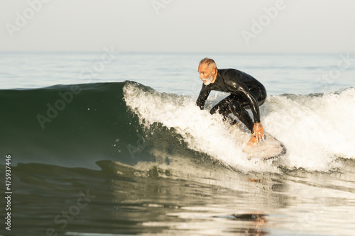 Stunning view of a mature surfer catches a wave