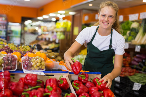 Valokuva Fifteen-year-old girl who works part-time in a store as a trainee saleswoman put
