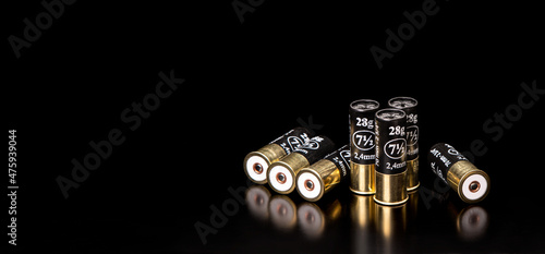Shotgun cartridges on a black back. Ammunition for smooth-bore weapons. Reflections on a glossy surface.