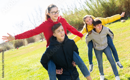 Happy teens compete with each other in spring park
