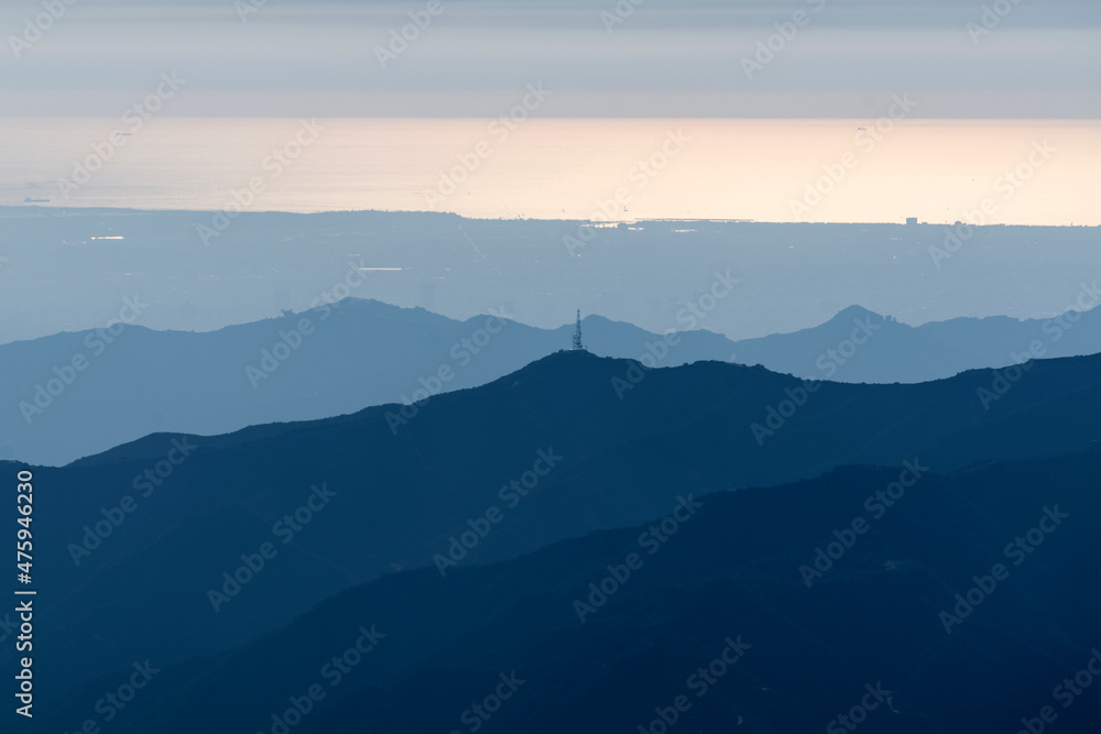Mountain ridges with the shimmering Pacific ocean in distance.  Shot taken from Mt Lukens in the San Gabriel Mountains area of Los Angeles California.