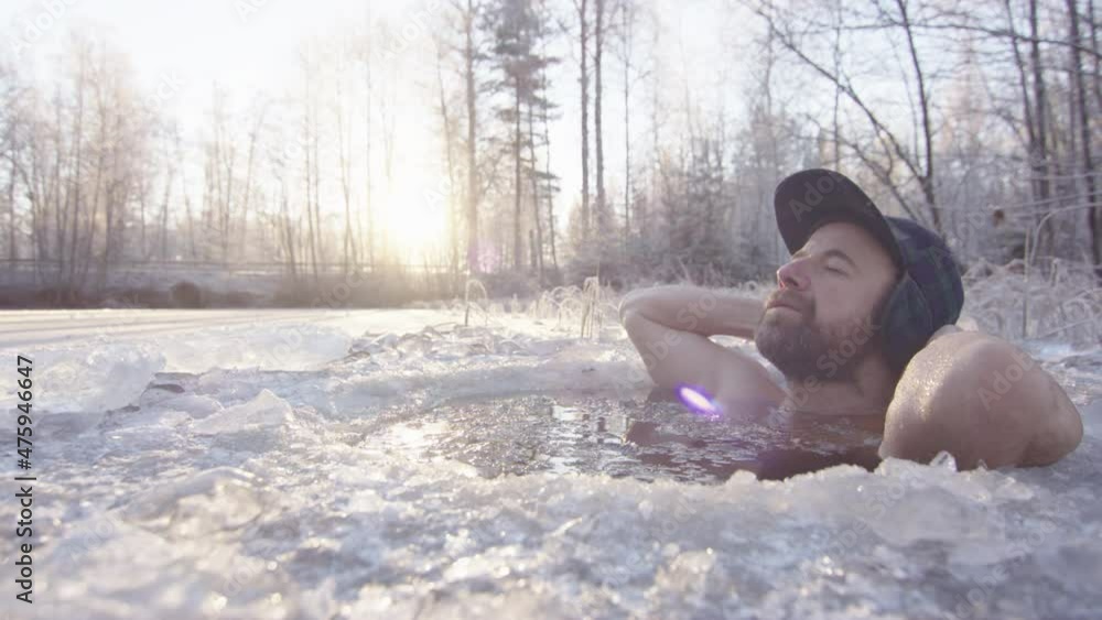 LENS FLARE - The ice bather looks deeply relaxed in the freezing water, conscious breathing LENS FLARE - The ice bather looks deeply relaxed in the freezing water, conscious breathing