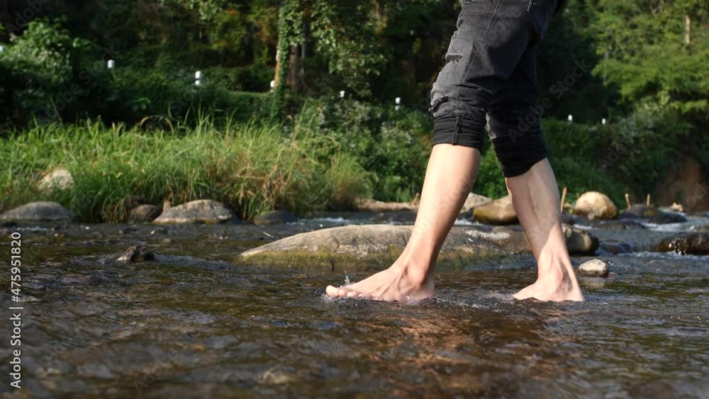 Male feet walking in water river flowing through the mountains. Male feet walking in water river flowing through the mountains.