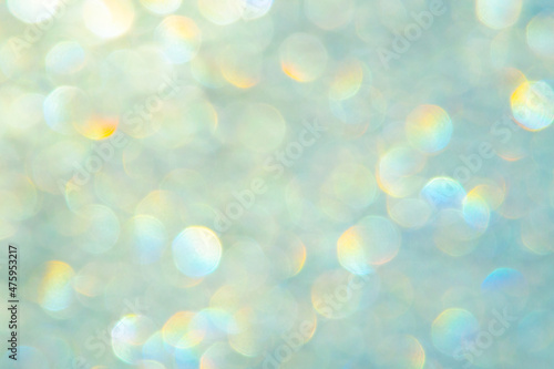 bright glitter background: bokeh effect from many colored lights on frozen glass, toning