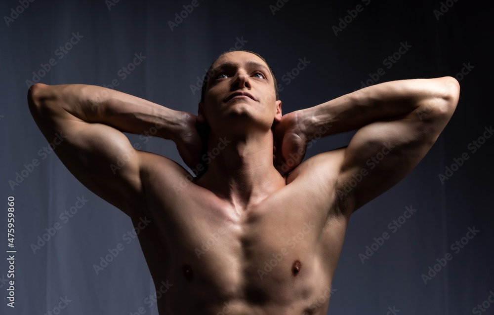 man posing with dumbbells. model in the studio poses, shows muscles, beautiful body relief. spotr, healthy lifestyle man posing with dumbbells. model in the studio poses, shows muscles, beautiful body relief. spotr, healthy lifestyle