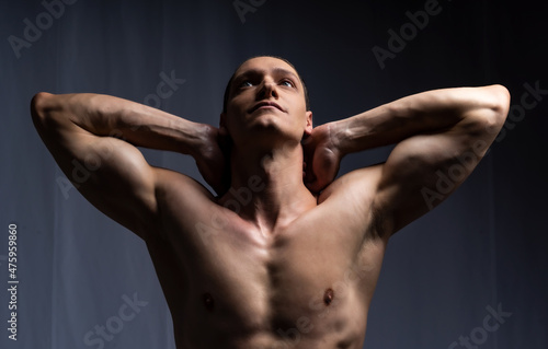 man posing with dumbbells. model in the studio poses, shows muscles, beautiful body relief. spotr, healthy lifestyle