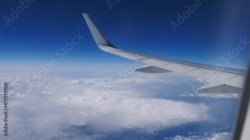 View from the window on the wing of the plane and passing clouds. photo