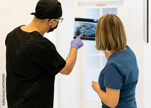 Two doctors checking x-ray image in hospital, quality photo 