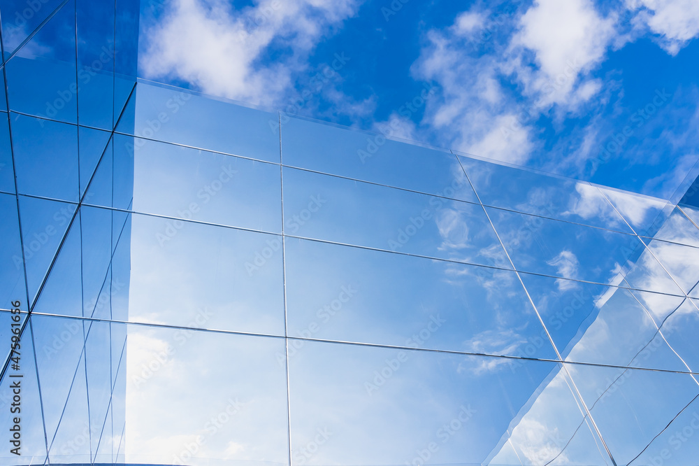 Reflection of blue sky in clouds on glass surfaces of modern building Reflection of blue sky in clouds on glass surfaces of modern building