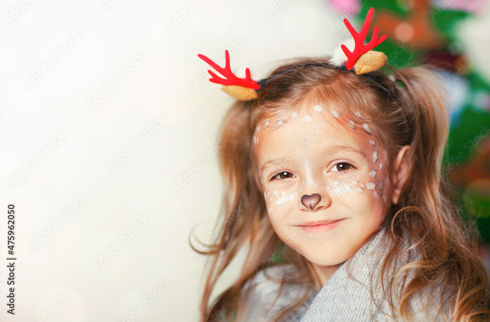a girl with the makeup of a Christmas fawn is smiling