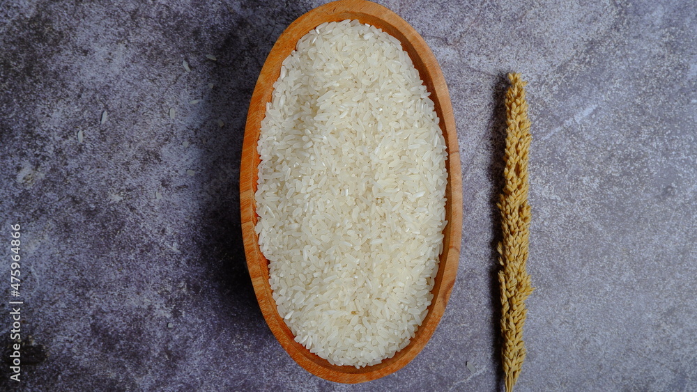 Rice in an oval wooden bowl and some kitchen ornaments neatly and beautifully arranged on a table. food and beverage concept. High angel view. Flat lay. Rice in an oval wooden bowl and some kitchen ornaments neatly and beautifully arranged on a table. food and beverage concept. High angel view. Flat lay.