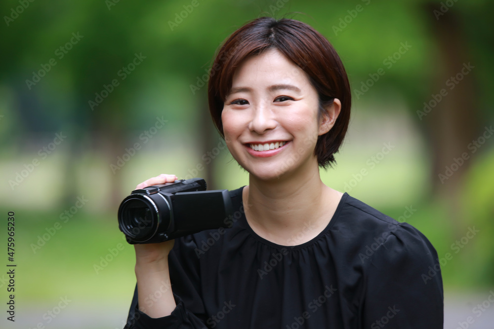 ビデオカメラで撮影する女性