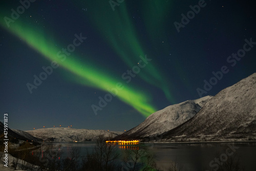 Breathtaking Aurora Borealis over mountain and lake water in Kvaloya, Arctic region in Norway photo