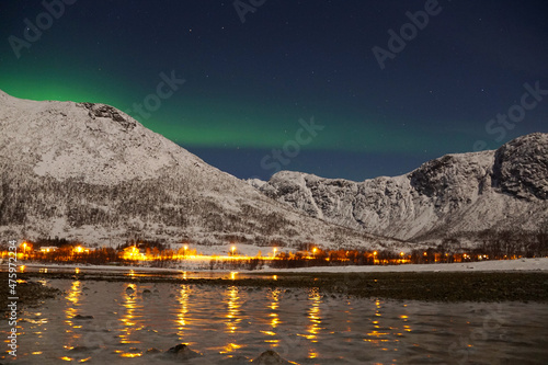 Breathtaking Aurora Borealis over mountain and lake water in Kvaloya, Arctic region in Norway photo