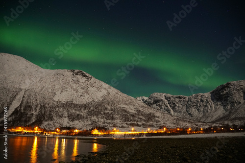 Aurora Borealis over mountain and lake water in Kvaloya, Arctic region in Norway photo