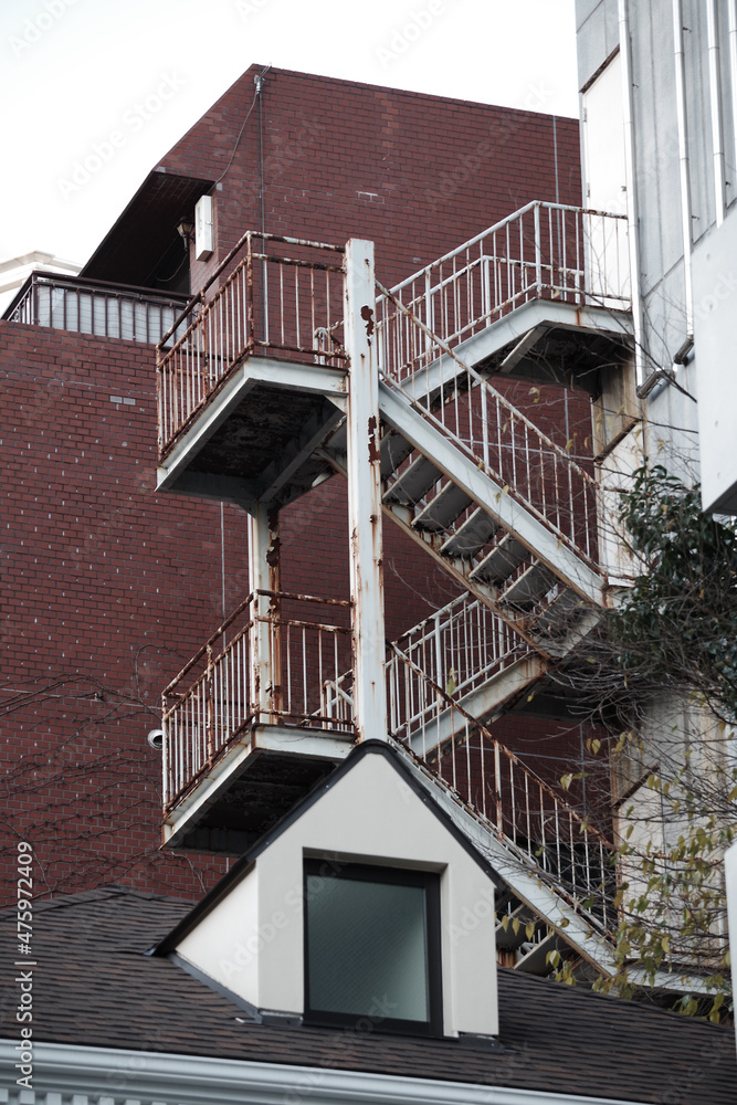 Fototapeta premium 赤茶色のタイルの建物と寂びた外階段 東京、赤坂４丁目の街の風景