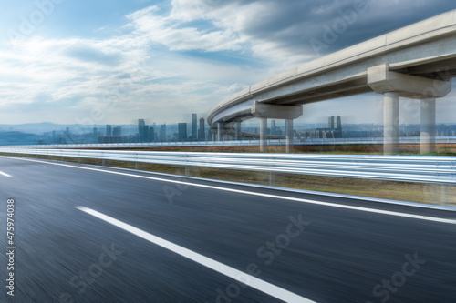 Motion blurred asphalt highway and modern city skyline with buildings